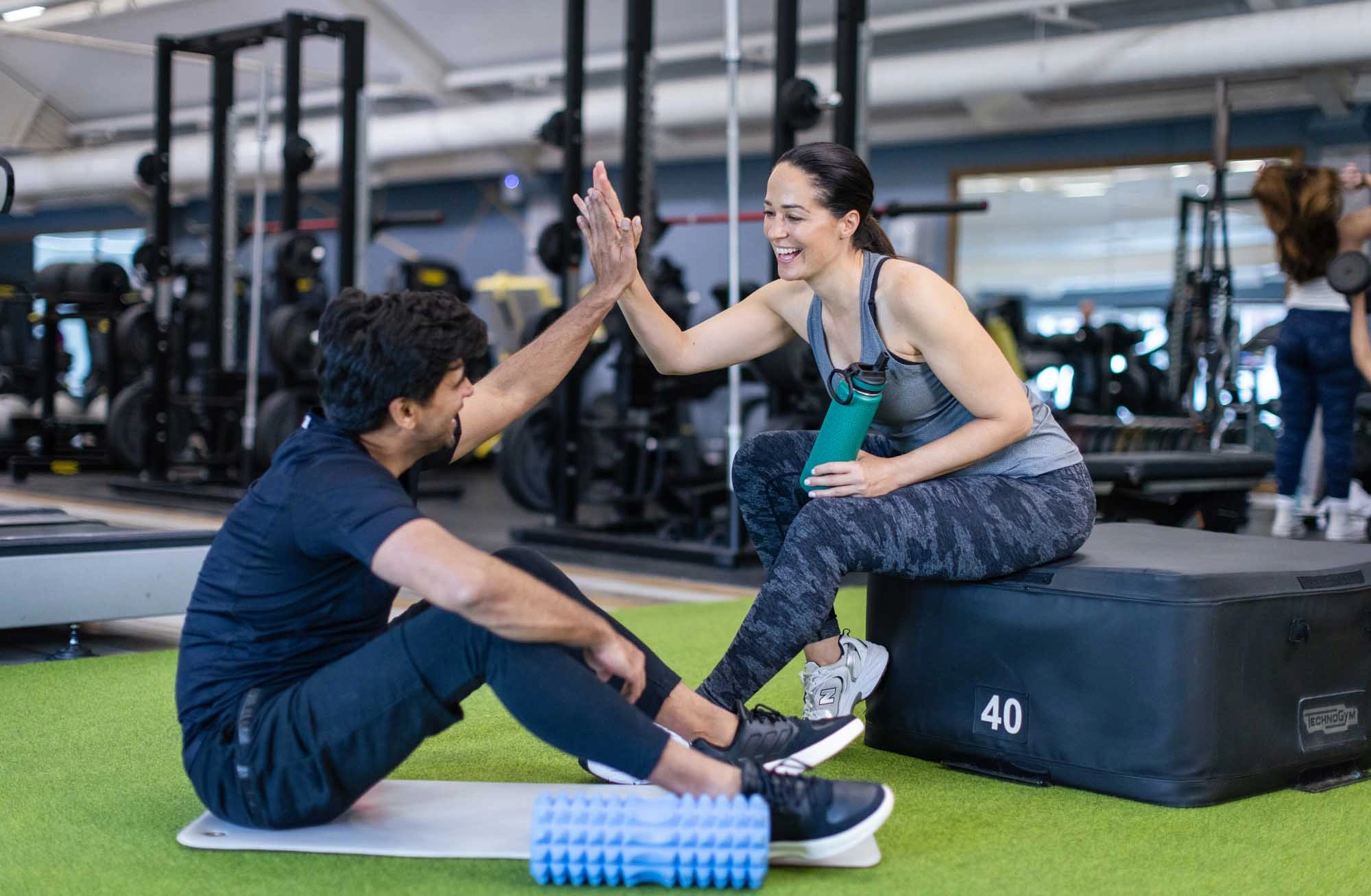 couple in gym high fiving