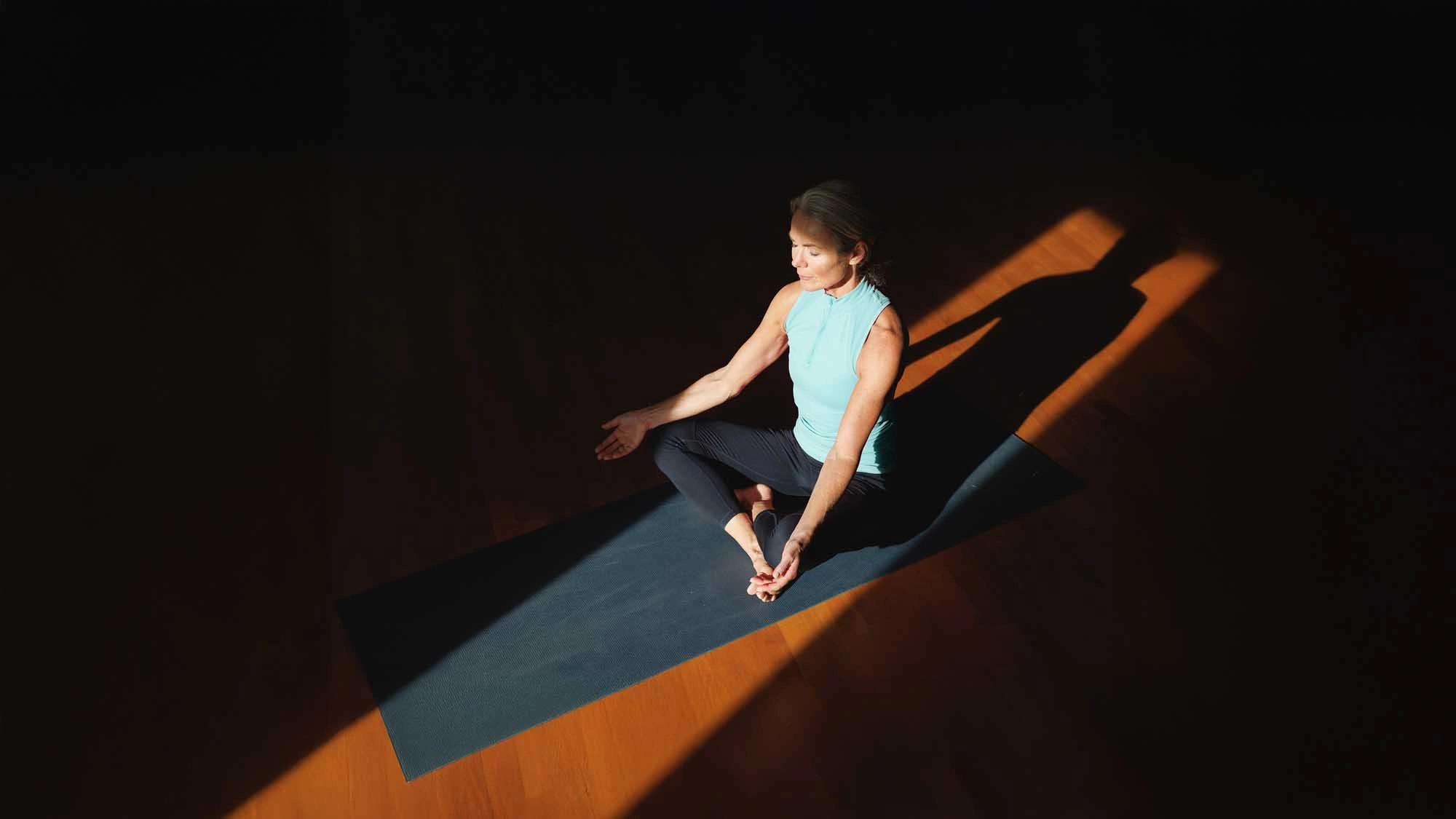 lady in dark room meditating