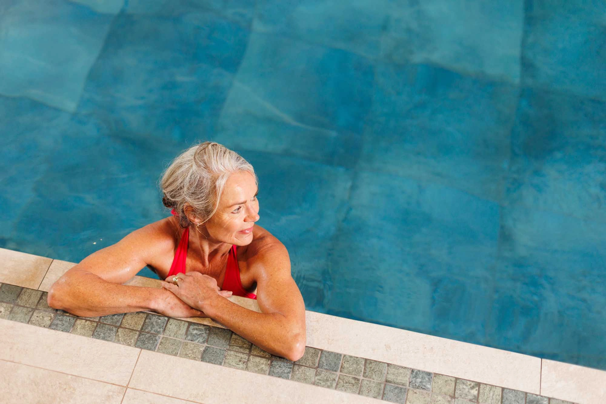 lady resting on the side of the pool
