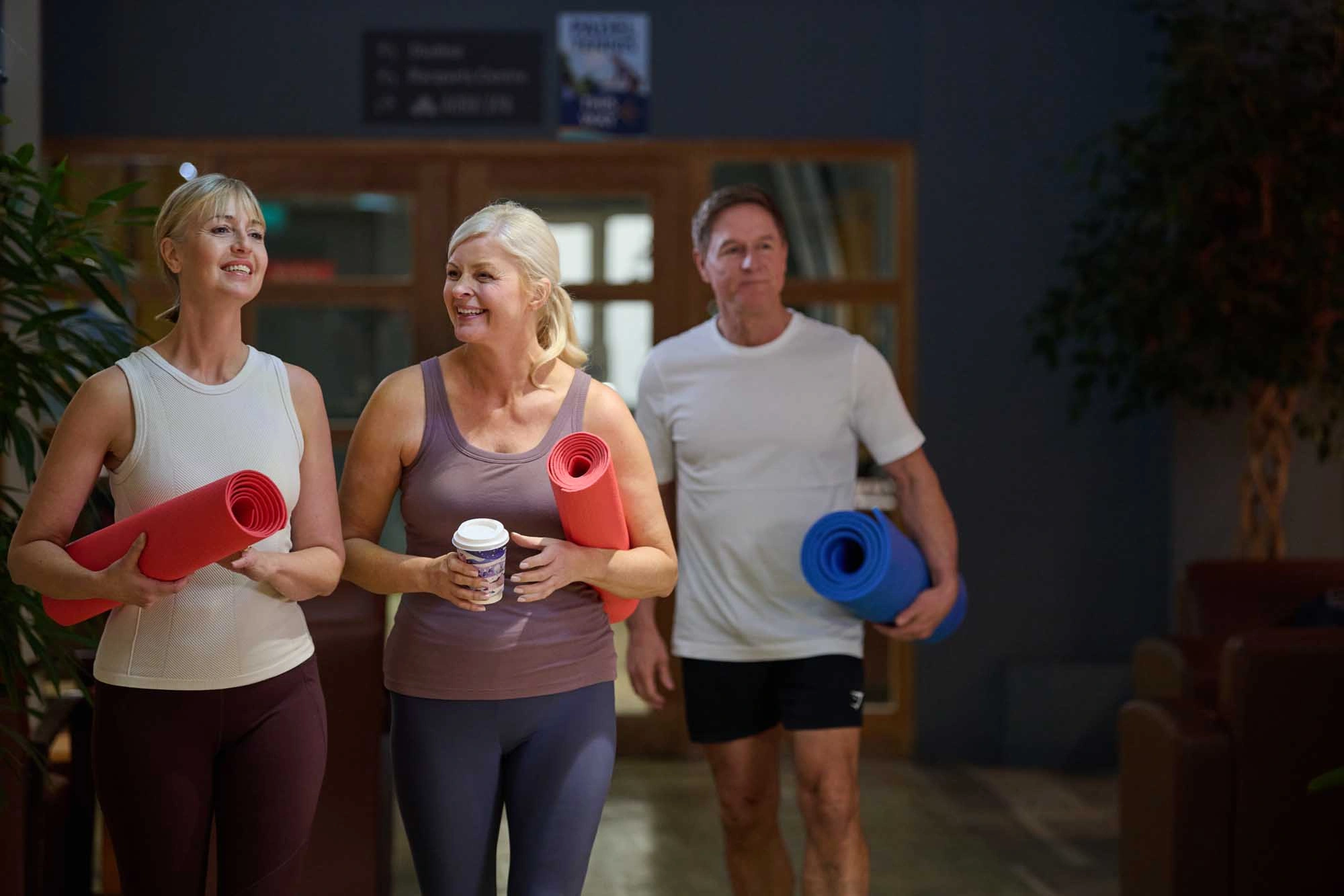 two ladies with yoga mats chatting