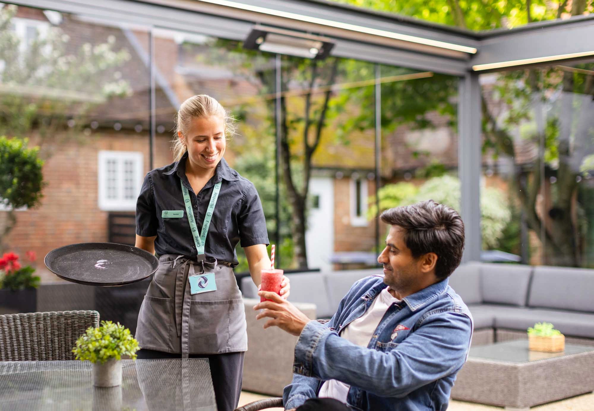 lady serving a man a smoothie