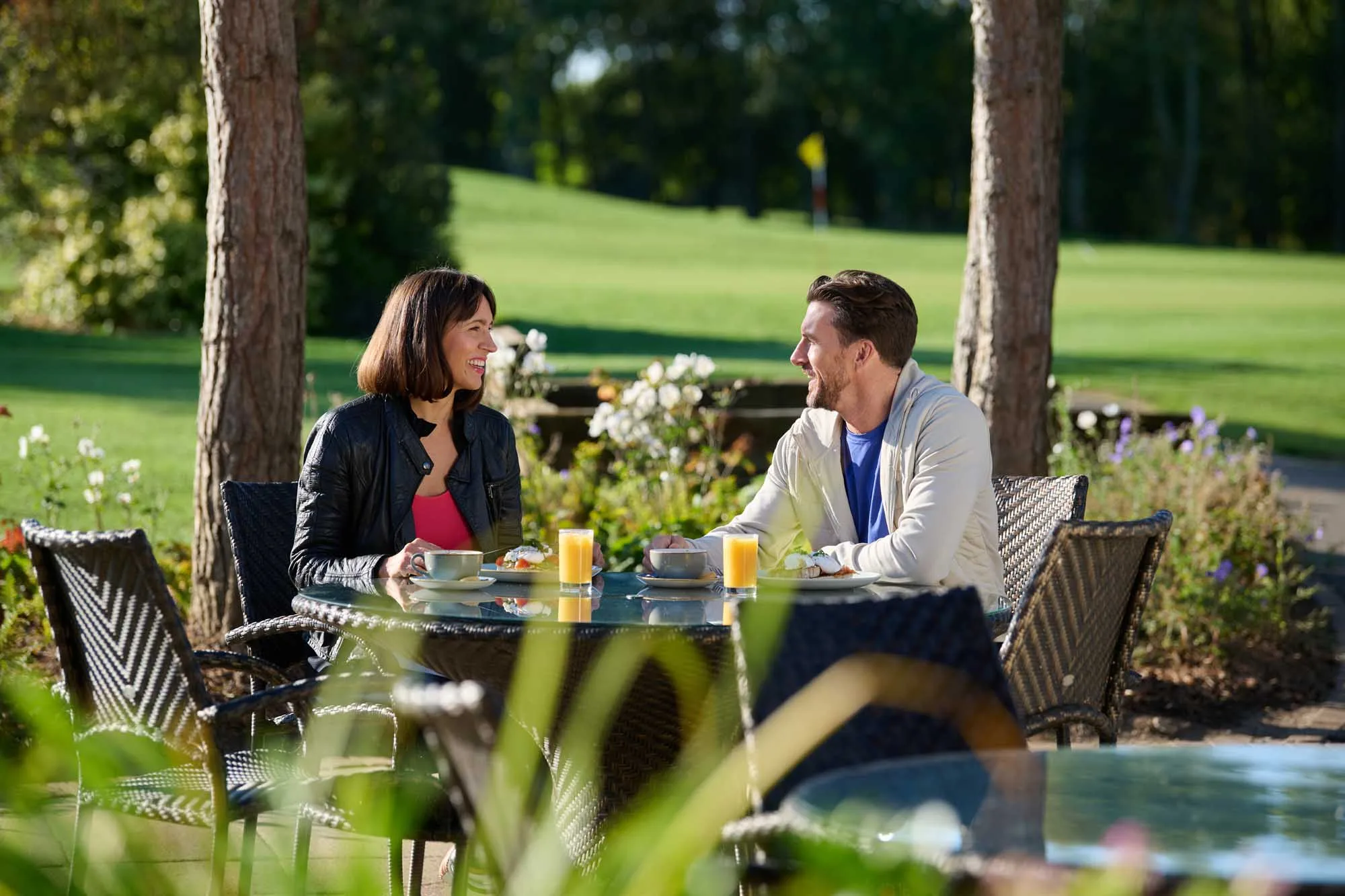 lady and man relaxing outside in countryside enjoying an orange juice