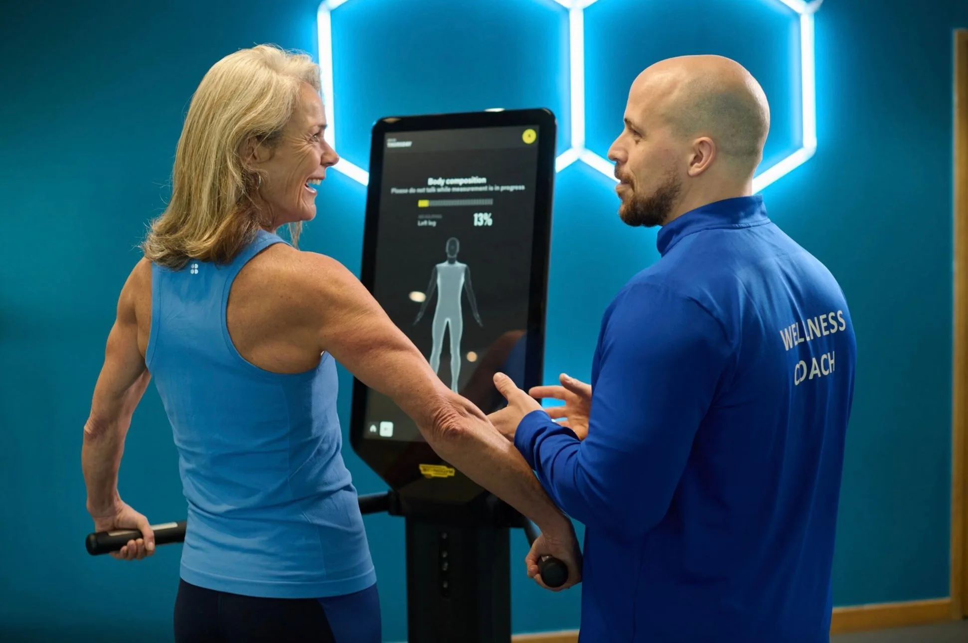 lady being guided by a gym instructor